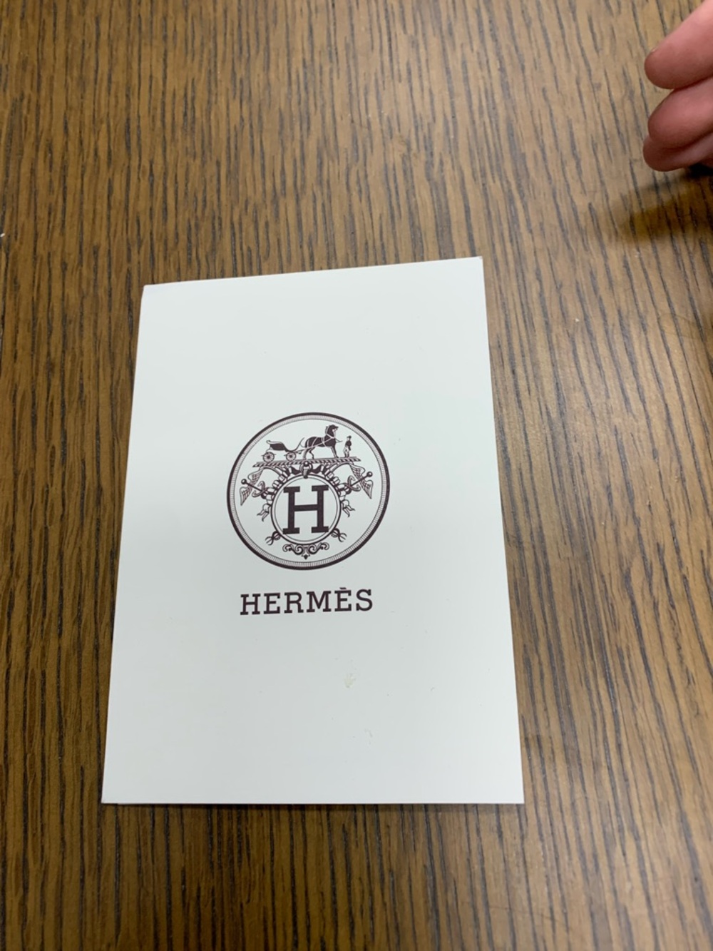 Hermès white card with brown logo and crest